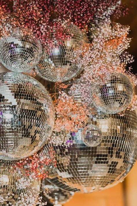 Custom made hanging installation for wedding dance floor with sprays of colorful small blooms and varying sizes of mirrored disco balls. Christmas Wedding Dance Floor, Disco Ball And Flowers Aesthetic, Disco Ball Arrangement, Disco Ball Dance Floor, Hannah And Samuel, Disco Ball Installation, Wedding Installation, Groovy Wedding, Disco Ball Decorations