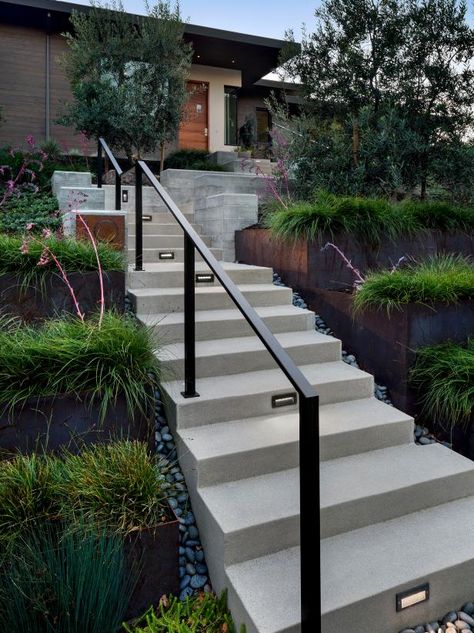 Retaining Wall Stairs With Railing, Modern Outdoor Stair Railing Ideas, Outdoor Entry Stairs, Modern Exterior Handrail, Modern Exterior Stairs, Black Outdoor Railing Front Porches, Modern Handrails For Stairs Outdoor, Exterior Handrail Design, Exterior Handrails For Steps