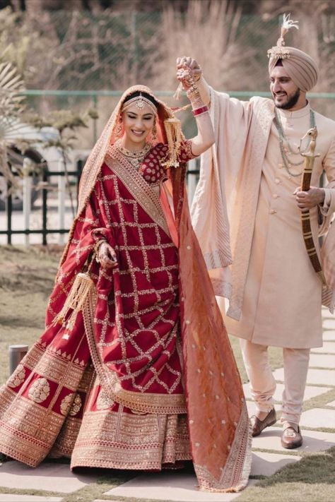 Sikh bride in a deep red Sabyasachi lehenga with the groom in an Ivory outfit भारतीय दुल्हन संबंधी, Best Indian Wedding Dresses, Indian Wedding Lehenga, Groom Dress Men, Indian Groom Wear, Wedding Dresses Men Indian, Latest Bridal Lehenga, Couple Wedding Dress, Indian Bride Outfits