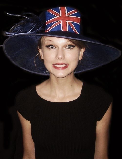 a woman wearing a blue hat with a british flag on it's brim