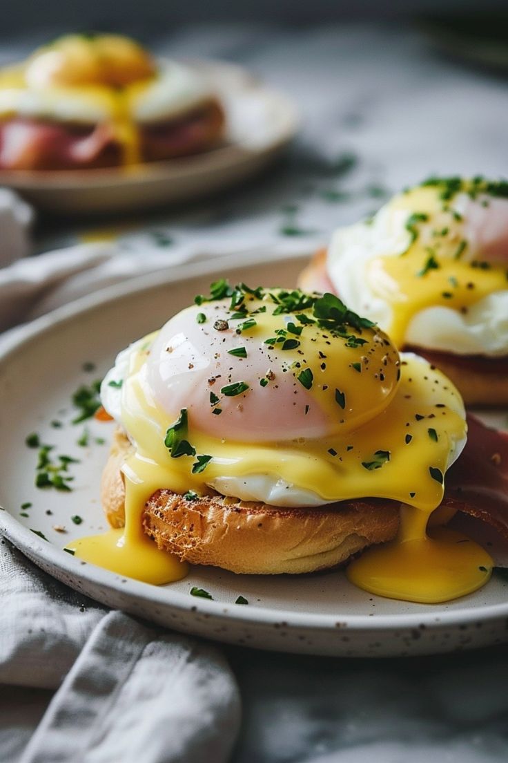 two plates with eggs, ham and cheese on them