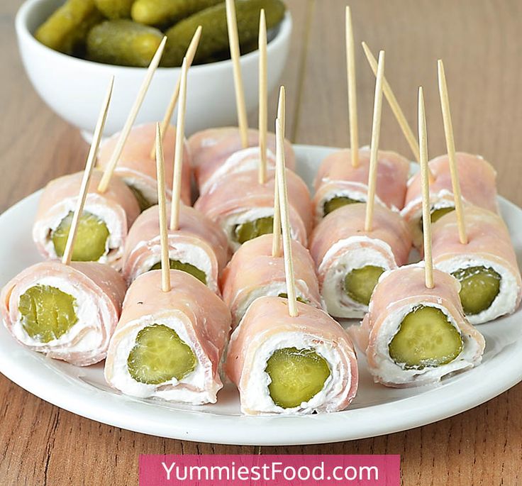 several appetizers are arranged on a plate with pickles