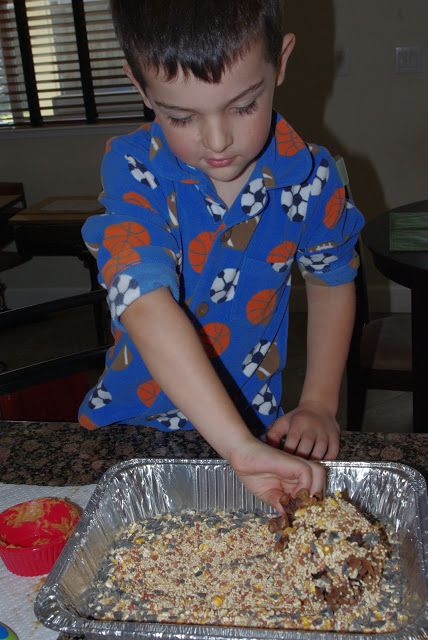 a young boy in blue shirt preparing food on top of a metal pan and table