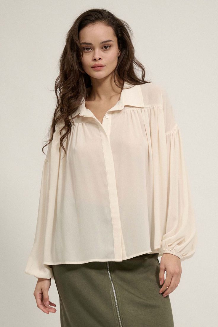 Solid chiffon shirt. Collared neckline. Button front closure. Long bubble sleeves with elastic cuffs. Drop shoulder. Gathered yoke Curved shirttail hem. Semi sheer. Oversized fit. 100% Polyester. Imported. Designed in LA. Model wears size S. Oversize Shirt, Big Sky, Vintage Canvas, Chiffon Shirt, Floral Chiffon, Oversized Shirt, Oversized Fits, Drop Shoulder, Black Shirt