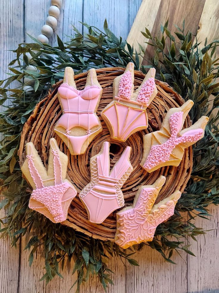 decorated cookies in the shape of women's bras on a wicker basket