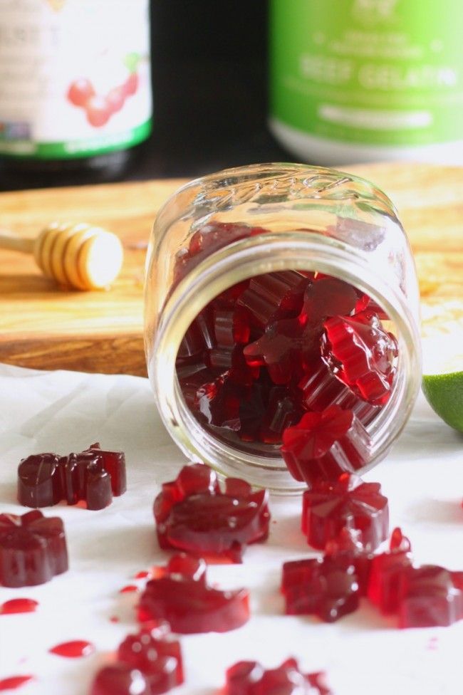 a jar filled with jelly sitting on top of a table next to a cutting board