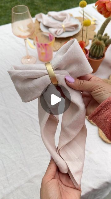 a woman is holding a pink bow at a table