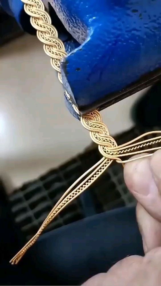 a close up of a person holding a blue object with gold chains attached to it