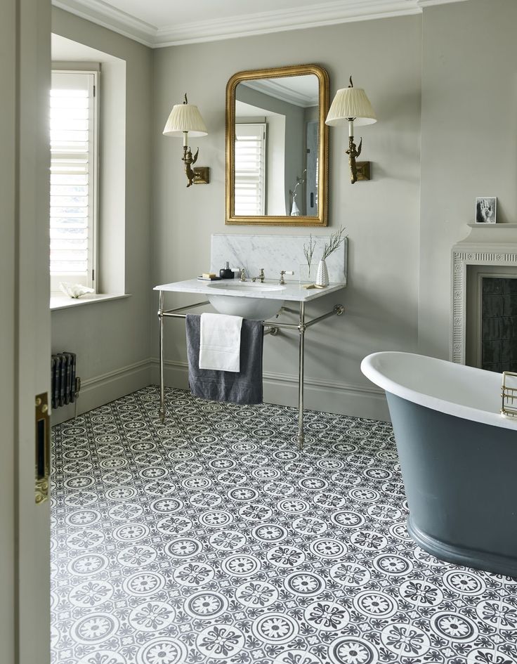 a bath room with a tub a sink and a mirror on the wall next to a window