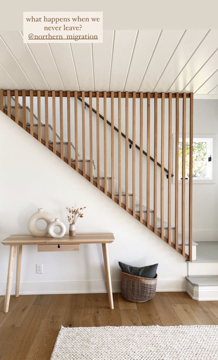 a white room with wooden stairs and a rug on the floor in front of it