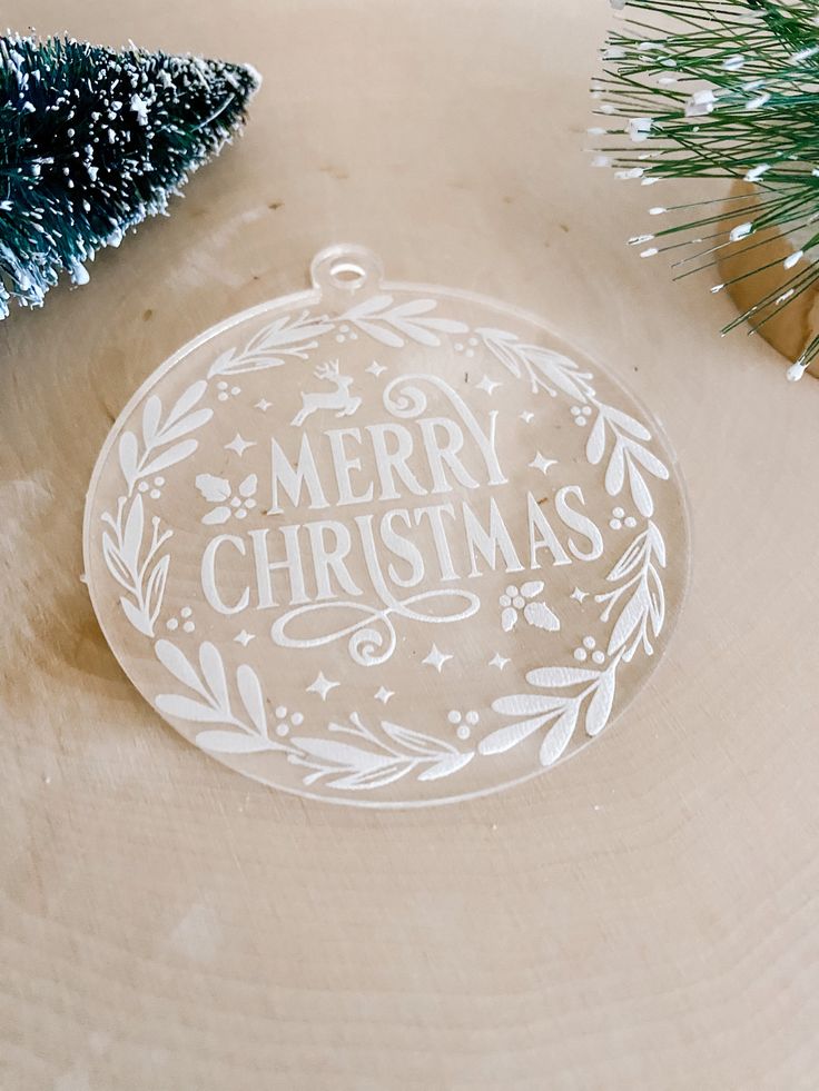 a christmas ornament sitting on top of a wooden table next to a tree