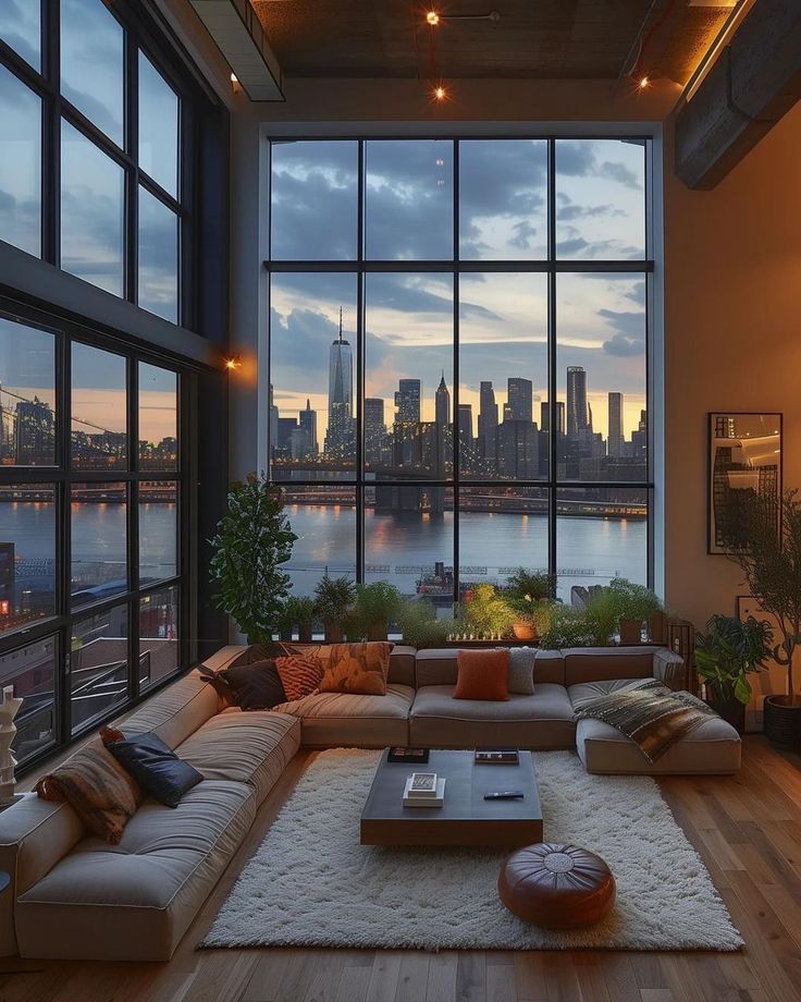 a living room filled with lots of furniture next to large windows and a view of the city