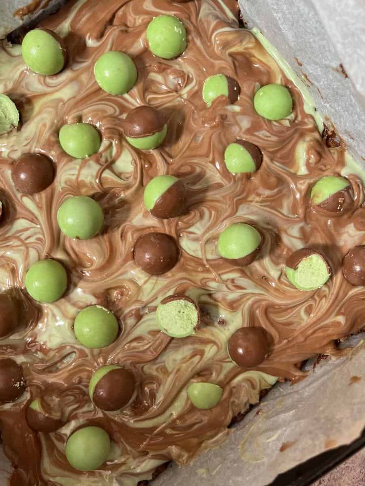 a cake with chocolate, green and white candies on it's top layer