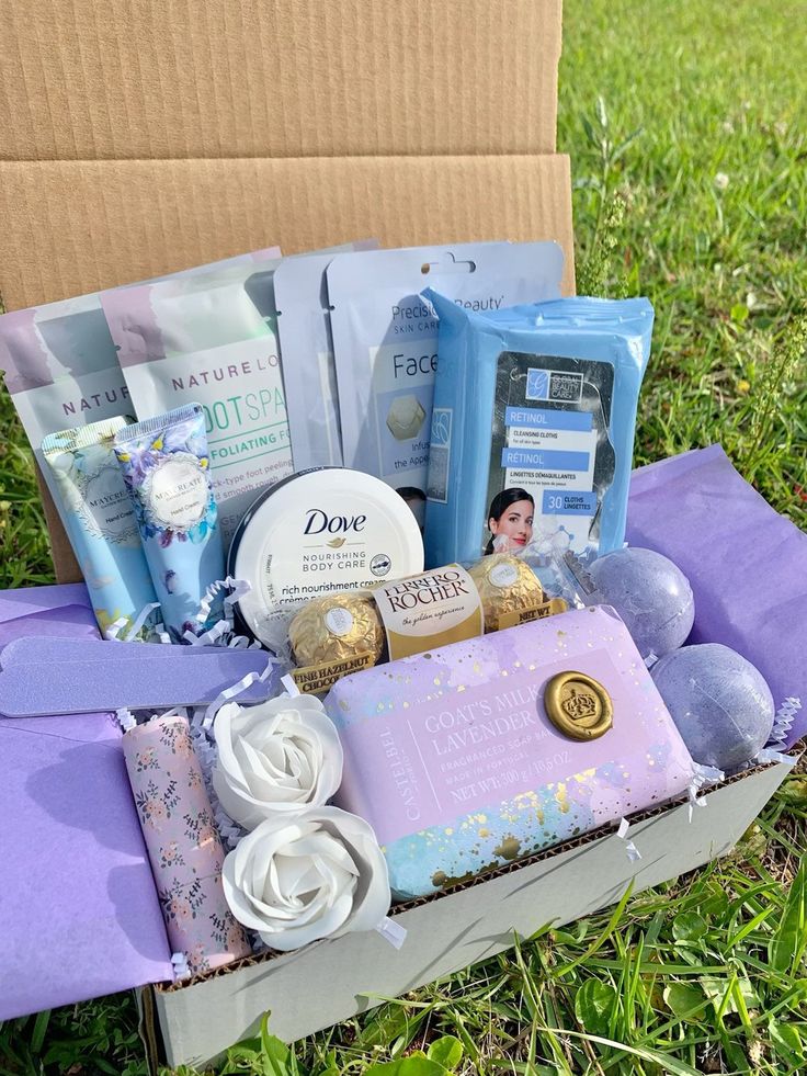 an open box on the grass with various items in it, including soaps and lotion