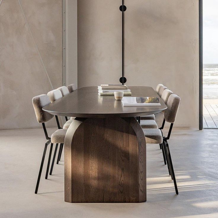 a dining room table with chairs around it and a book on the table next to it