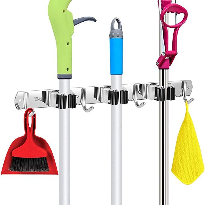 three different types of brooms hanging on a rack with hooks and cleaning supplies attached to it