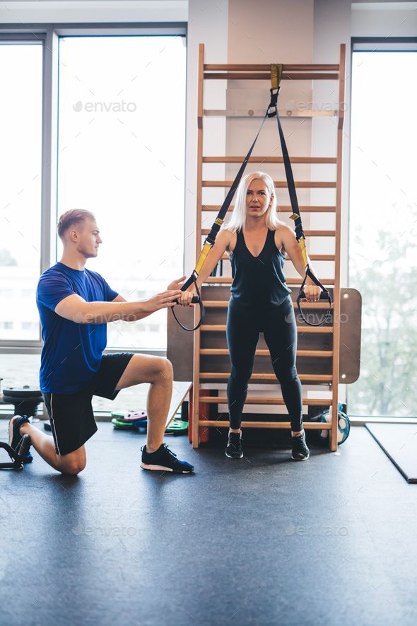 a man and woman in a gym doing exercises with exercise ropes - stock photo - images