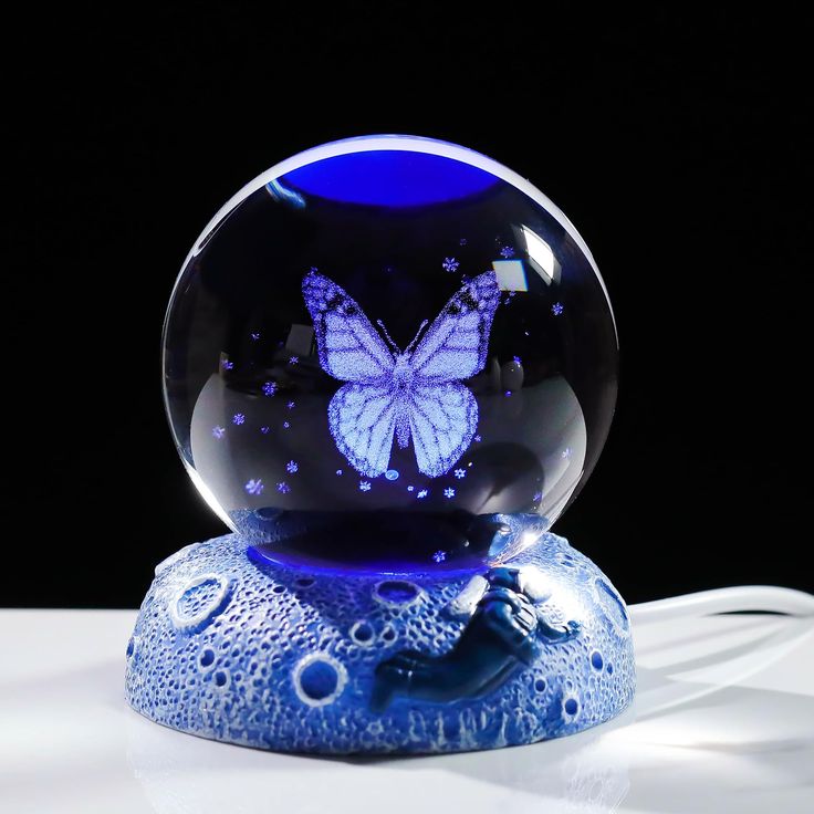 a blue glass ball with a butterfly on it