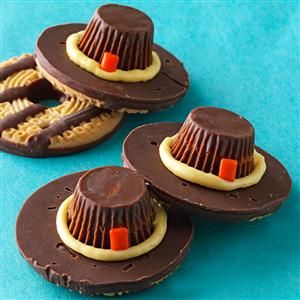 three chocolate hats with candy in them on a blue surface