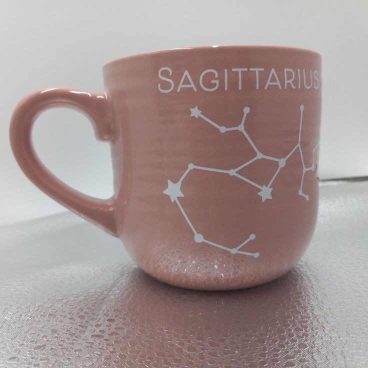 a coffee cup with the zodiac sign sagittarius on it's side