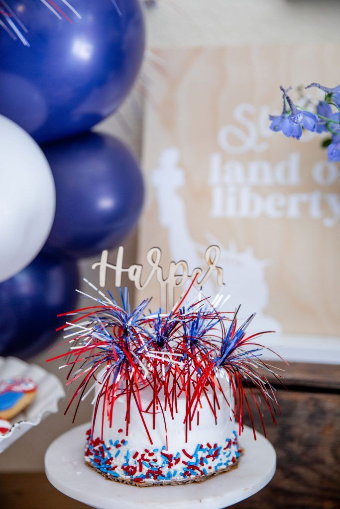 a birthday cake decorated with red, white and blue sprinkles on a table