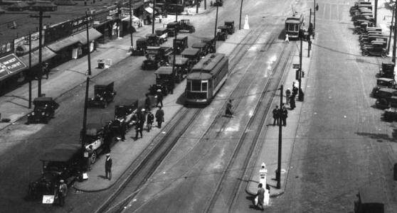 an old black and white photo of traffic on a city street