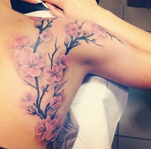 a woman's back with pink flowers on it