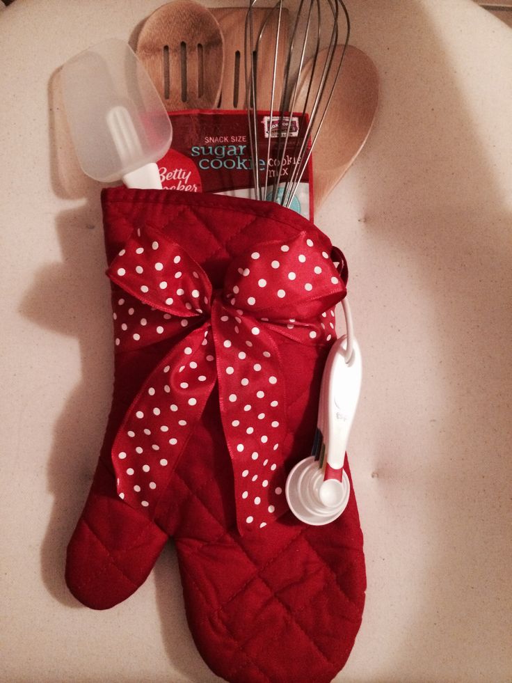 a red oven mitt with utensils in it sitting on top of a counter