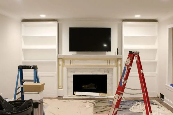 a living room that has been painted white and is being worked on by the painters