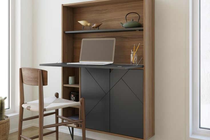 a laptop computer sitting on top of a wooden desk next to a chair and window