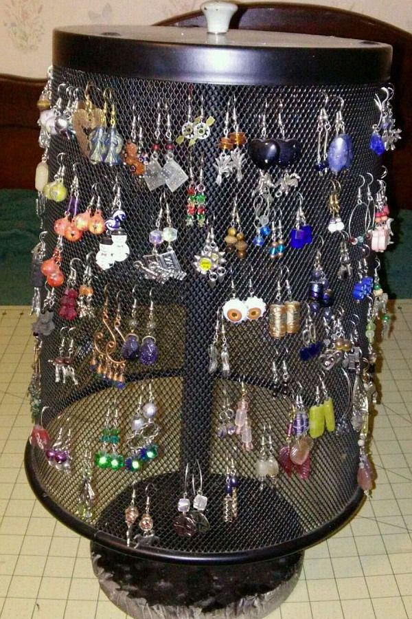 there are many earrings on display in the holder, and one is hanging upside down