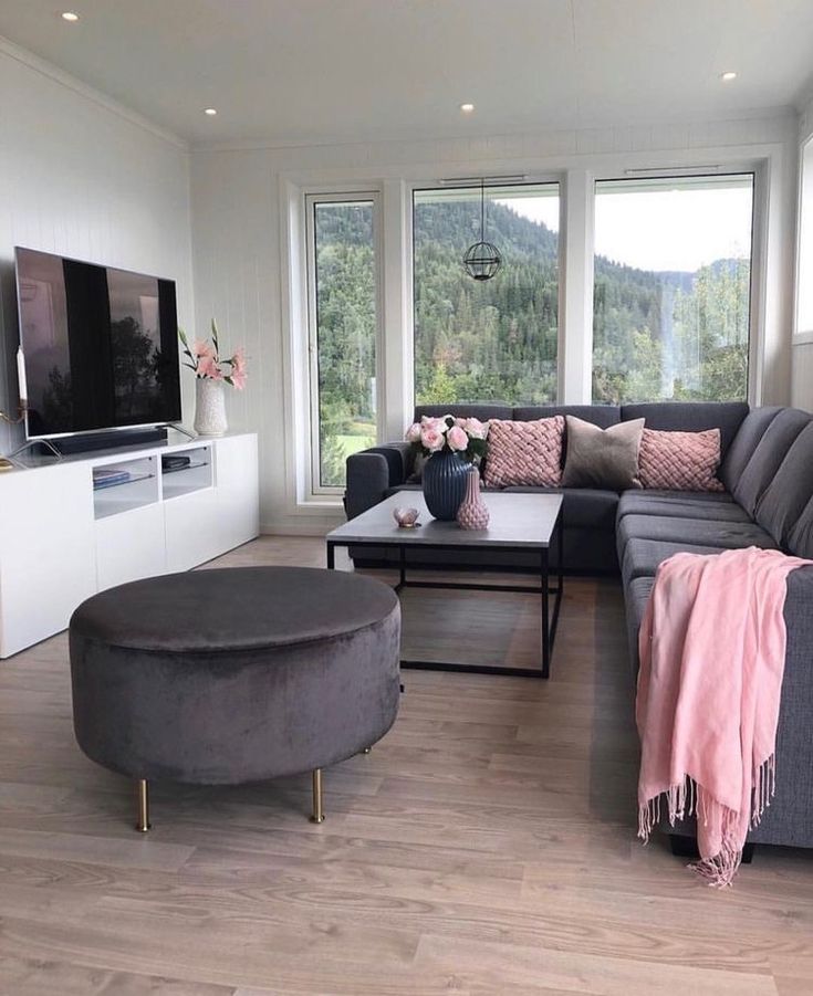 a living room filled with furniture and a flat screen tv on top of a wooden floor