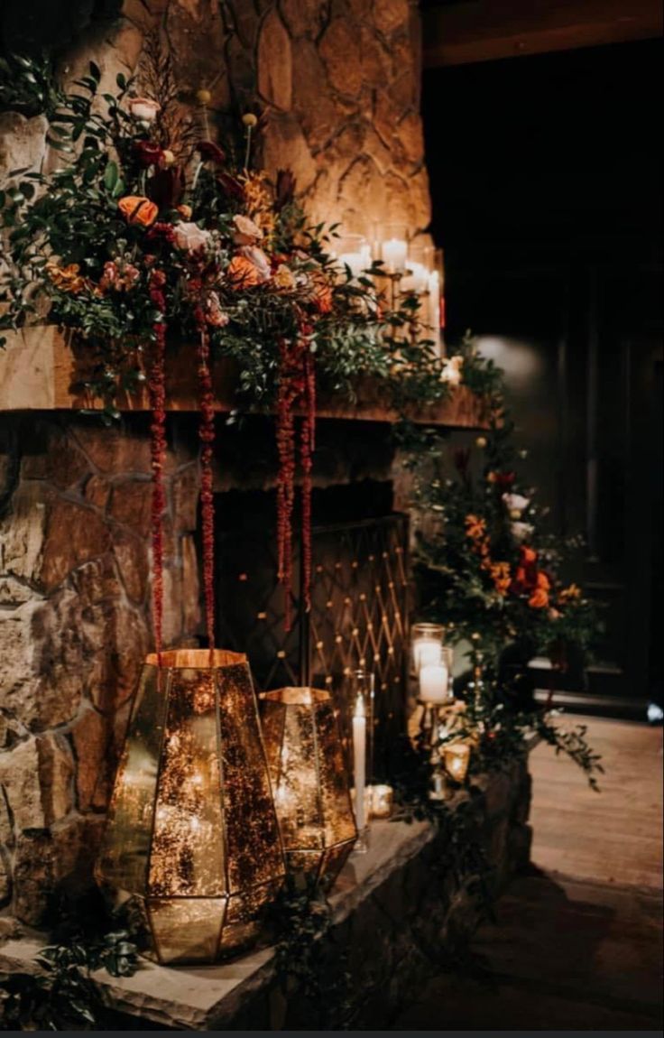 a fireplace with candles and flowers on it