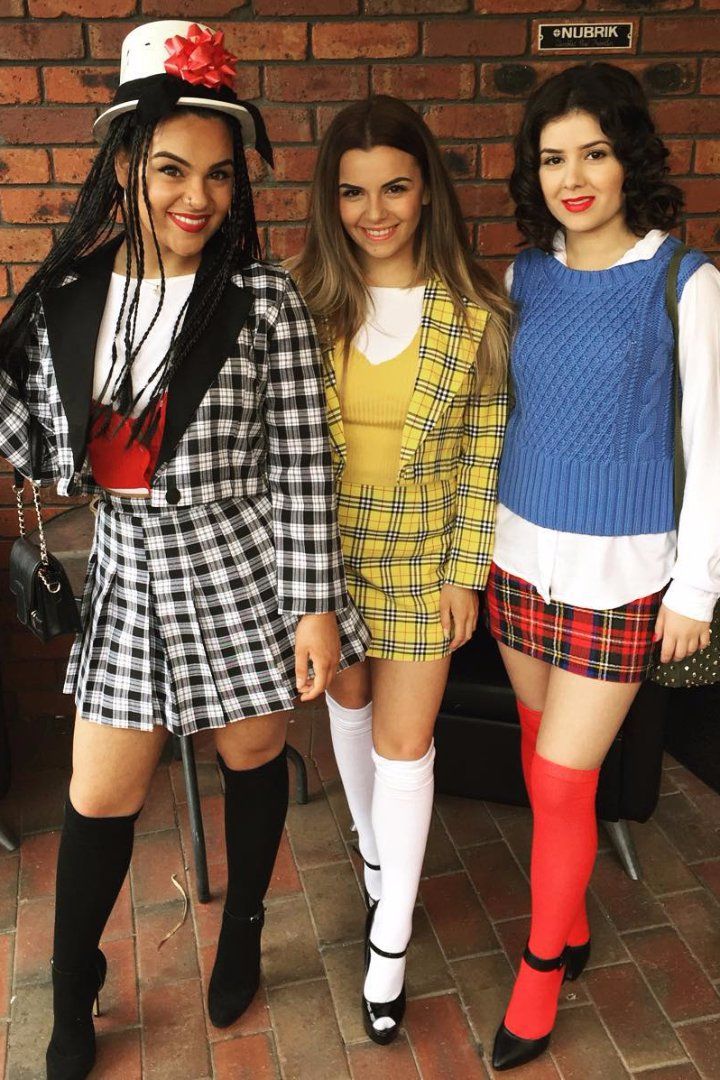 three girls dressed up in costumes posing for the camera