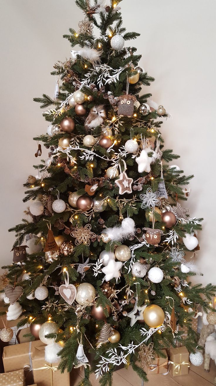 a decorated christmas tree with gold, silver and white ornaments