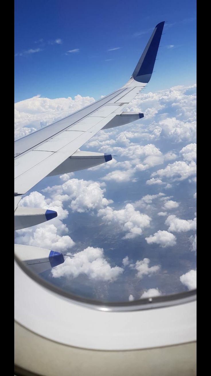 the wing of an airplane flying over clouds