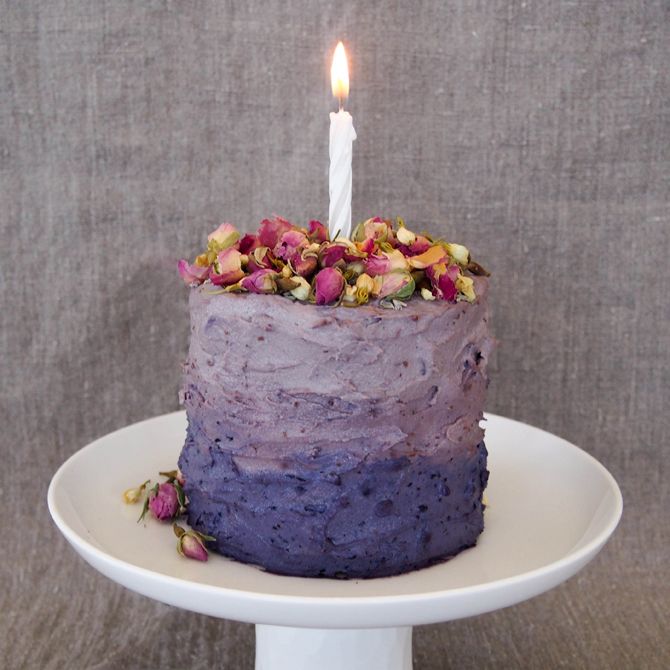 a purple cake with a single candle on top