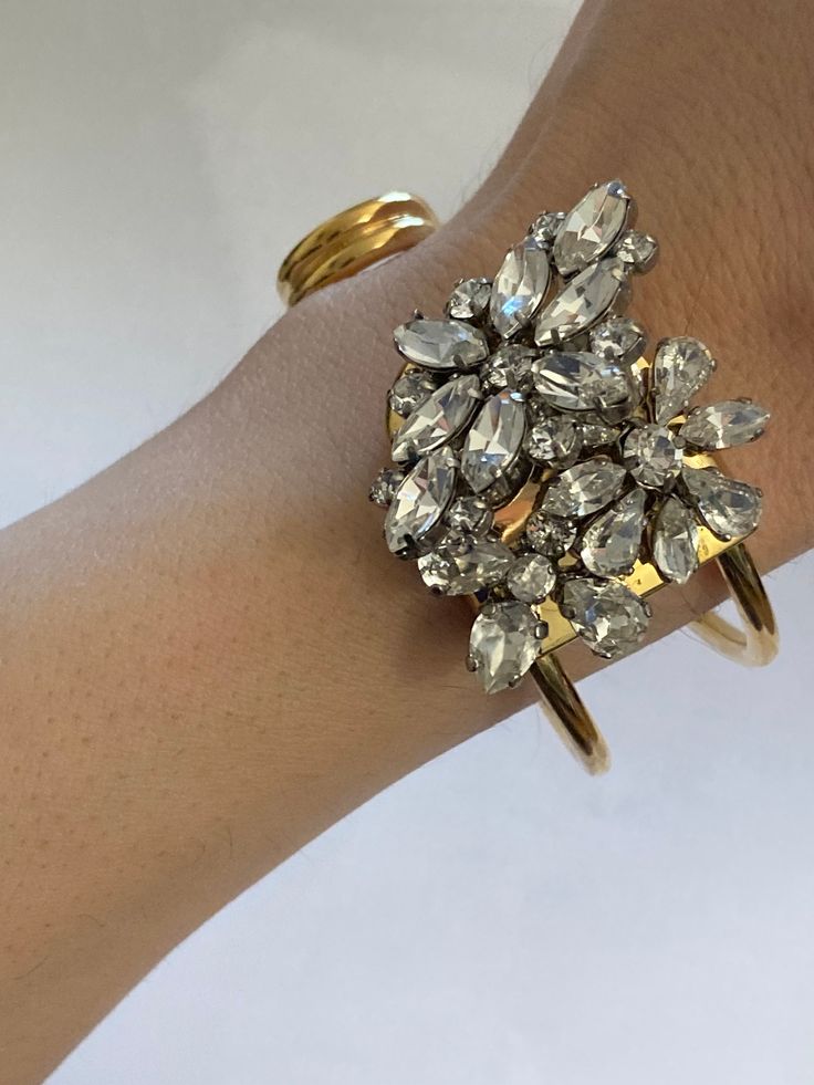 "Previously Used  Burberry Daisy Cuff Crystal  Metal: GOLD TONE ( Brass) Estimated Retail $650 Condition Very Good Weight 37grams inside diameter is estimated to be 2.3\" The inside circumference as a circle is about a little over 7\" ideal wrist for this would be 6.5' wrist the image shows a 6\" wrist which is comfortable but a little just a little on the large side the bracelet is slipped on from the side  Item is used but condition is very good you can see the high quality of this jewelry  th Luxury Cuff Bracelets For Party, Luxury Cuff Bracelet For Parties, Luxury Cuff Bangle Bracelet For Party, Elegant Cuff Bracelets For Party, Modern Yellow Gold Cuff Bracelet For Party, Luxury Adjustable Cuff Bracelet For Party, Adjustable Luxury Cuff Bracelet For Parties, Formal Cuff Bangle Bracelet With 17 Jewels, Elegant Round Cuff Bracelet For Party