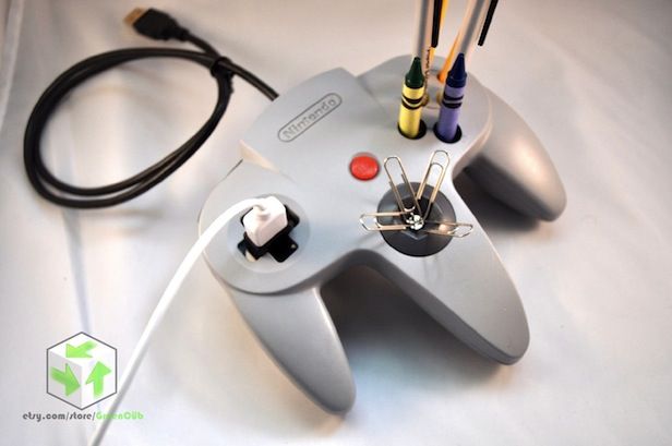 a video game controller sitting on top of a white table next to a black cord