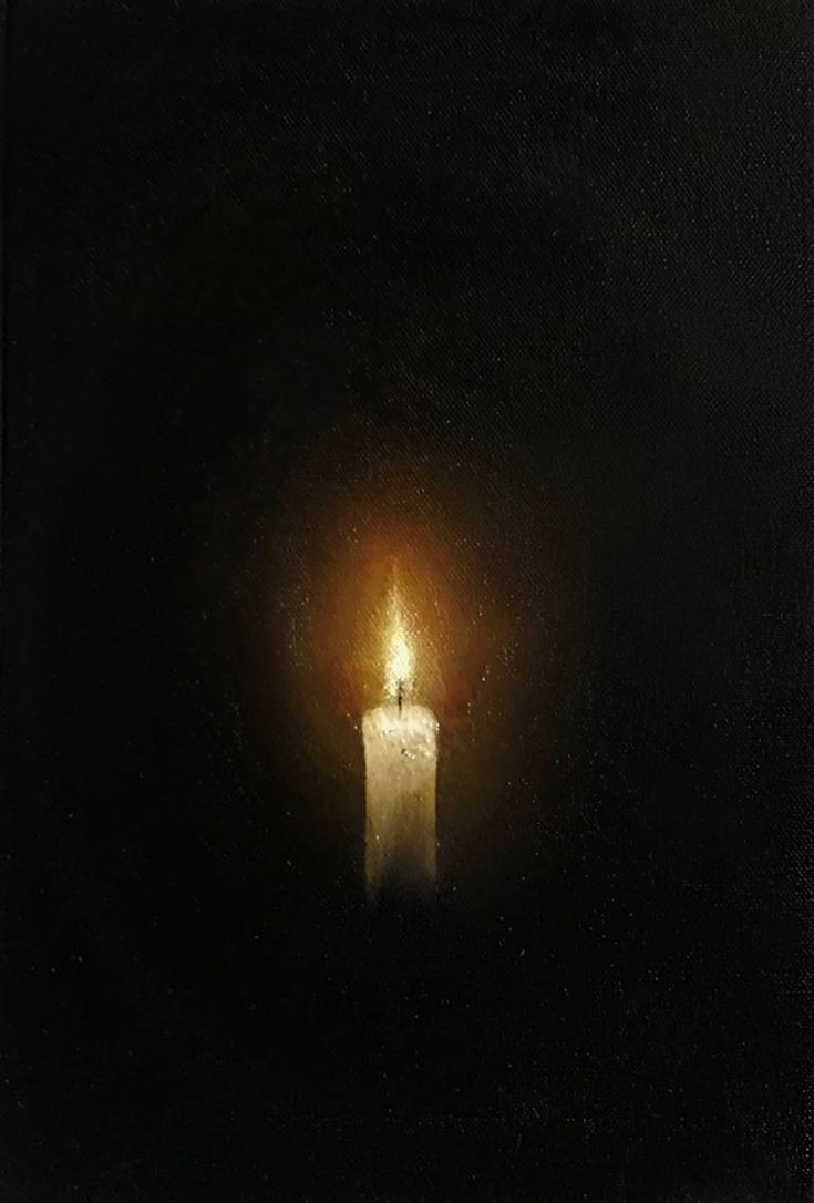 a lit candle in the middle of a dark room with only one light on it