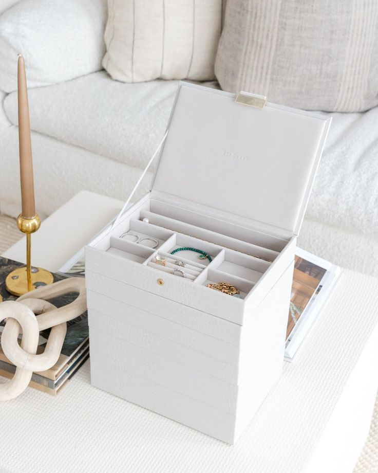 a white box sitting on top of a table next to a candle and some pictures