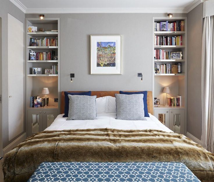 a bed sitting in a bedroom next to a window with bookshelves above it