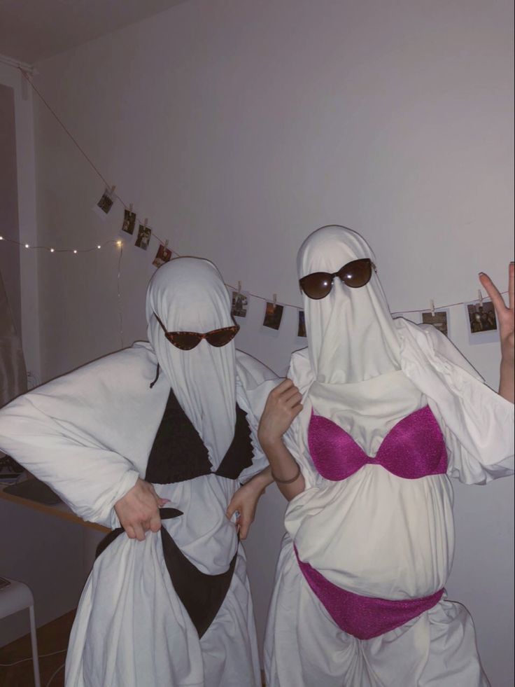 two people dressed in costumes standing next to each other with their hands up and fingers out