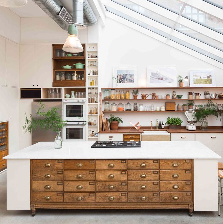 a kitchen with an island and lots of shelves on the wall next to each other