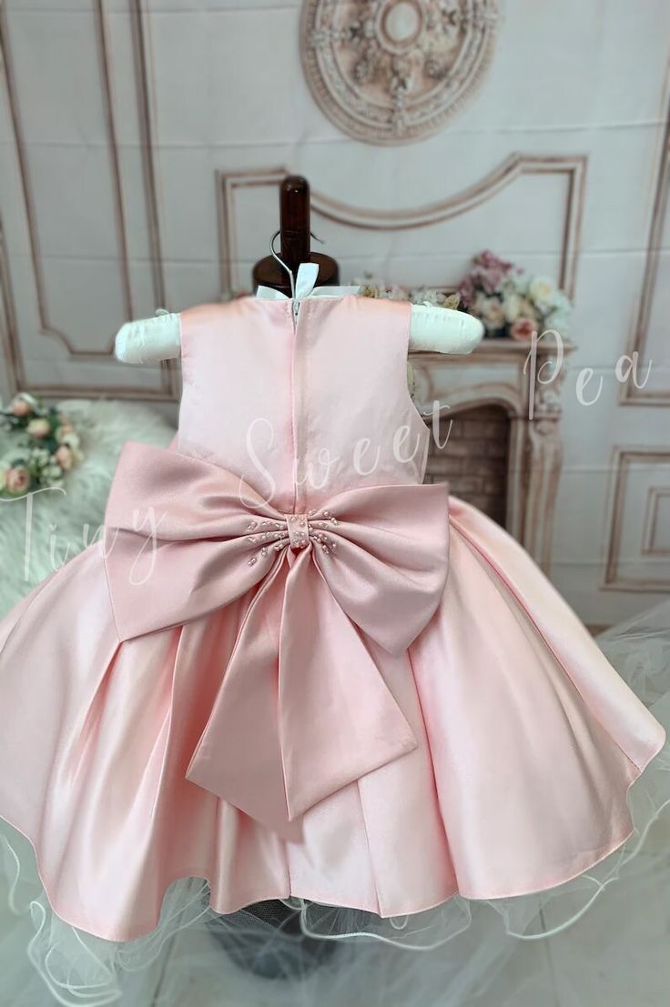 For a vision of chic elegance, look no further than our Glamorous Satin Dress for Little Girls. Available in either a regal white or stunning pink color, this high-quality, one-of-a-kind satin dress is perfect for any formal event or special occasion. The silhouette is classic, with a fitted bodice and a fluffy skirt that swirls delightfully at every twirl. Delicate patterns are beautifully embroidered on the bodice, giving an additional touch of sophistication. Each and every satin dress is met Party Dress With Satin Bow Ball Gown, Party Dress With Satin Bow, Ball Gown Shape, Elegant Ball Gown Princess Dress For Formal Occasions, Elegant Formal Princess Ball Gown Dress, Pink Satin Party Gown, Elegant Pink Sleeveless Satin Dress, Pink Sleeveless Satin Gown, Sleeveless Pink Satin Gown, Satin Princess Dress For Dress-up