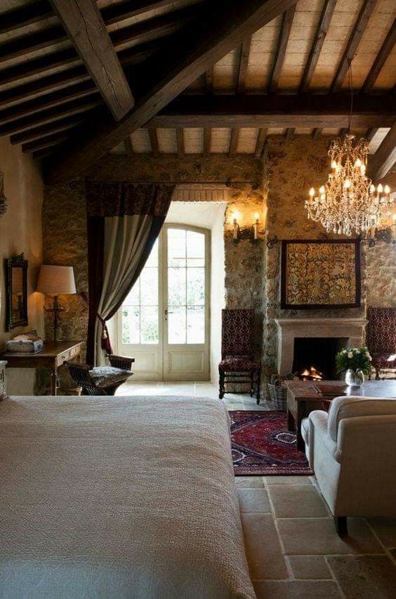 a bedroom with a large bed and chandelier hanging from the ceiling