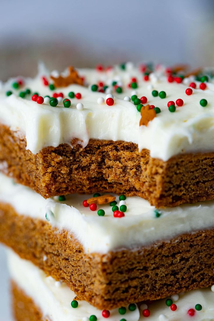 three pieces of cake with white frosting and sprinkles stacked on top of each other