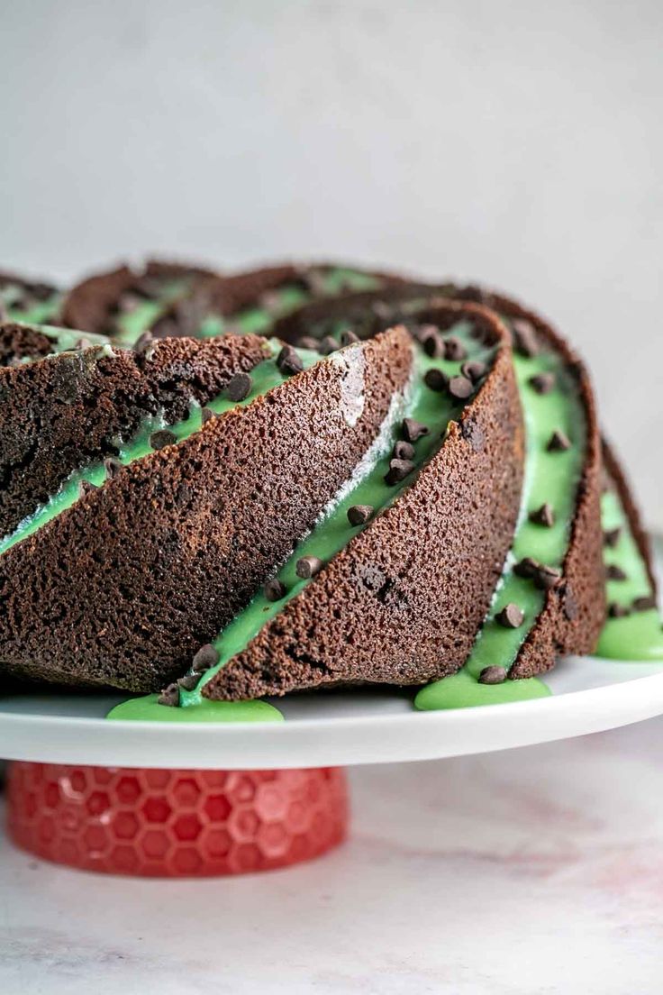 a chocolate cake with green icing on a white plate