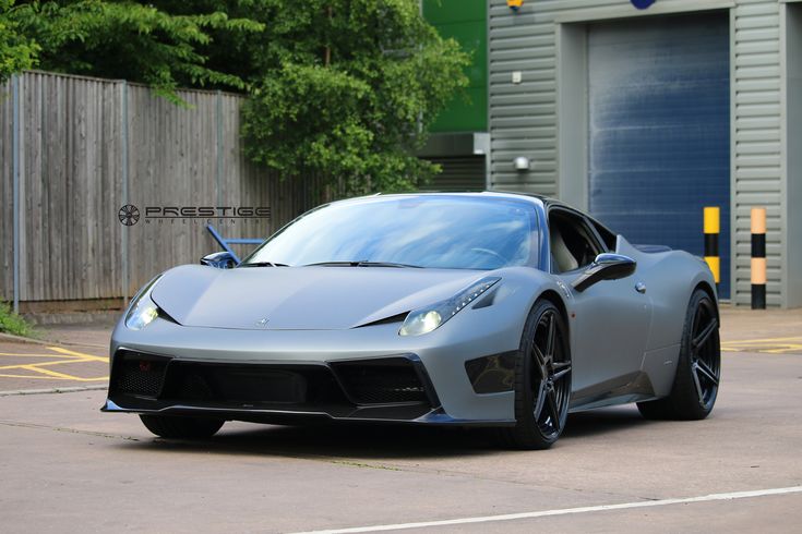 a silver sports car parked in front of a garage