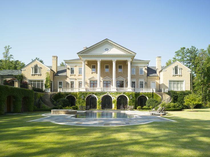 a large house with a pool in the middle of it's front lawn area